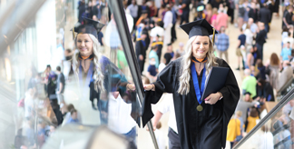 Mount Mercy graduate posing on stairs of Alliant Energy Powerhouse