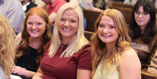 three people smiling at honors convocation