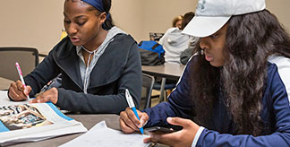 Two students taking notes