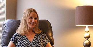 A counselor sitting in a chair, smiling