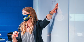 Professor with a mask teaching.