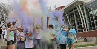 Students having fun outside with colorful paint.