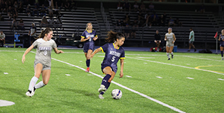 Women's soccer team playing with another soccer team