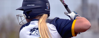 girl batting on plate for the mustangs