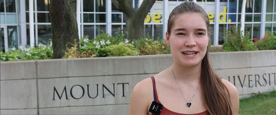 A student on the track, speaking to the camera