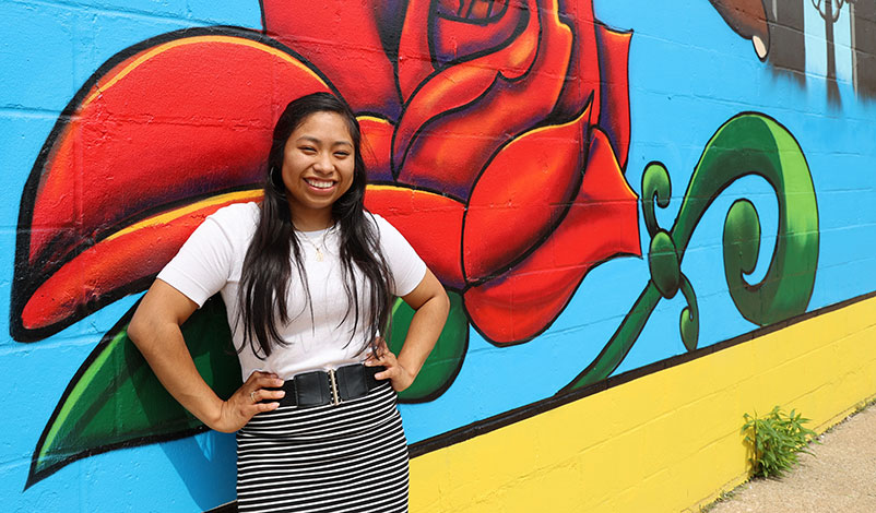 Alma, posing in front of a Cedar Rapids mural