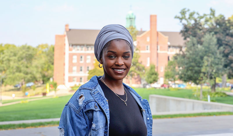 Cecilia Bwanakweri standing outside of the university center at mount mercy university