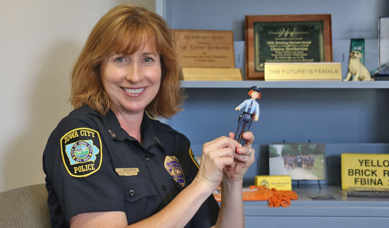 Denise, holding up a figurine of a policewoman