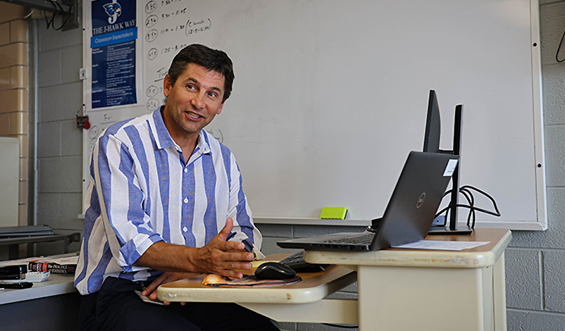 Terry sitting at his desk, explaining math concepts