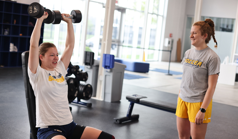 woman lifting weights above head