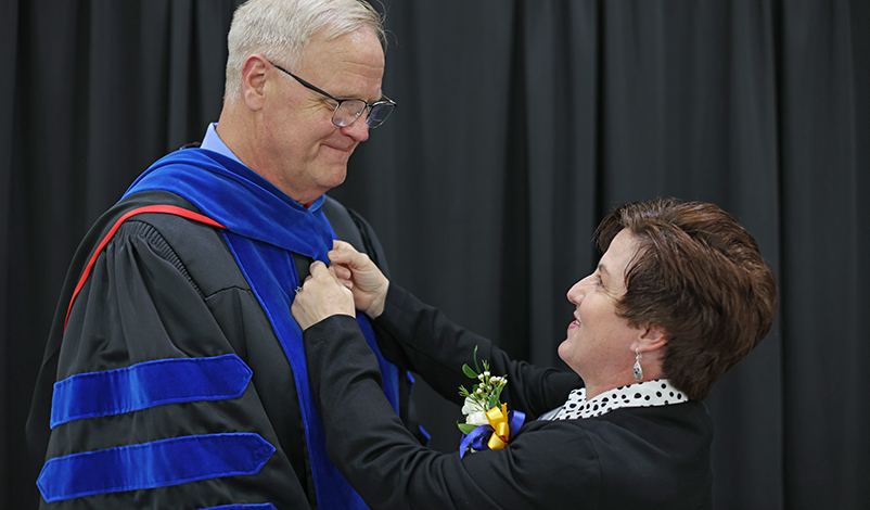 President Olson and his wife, who is straightening his robes
