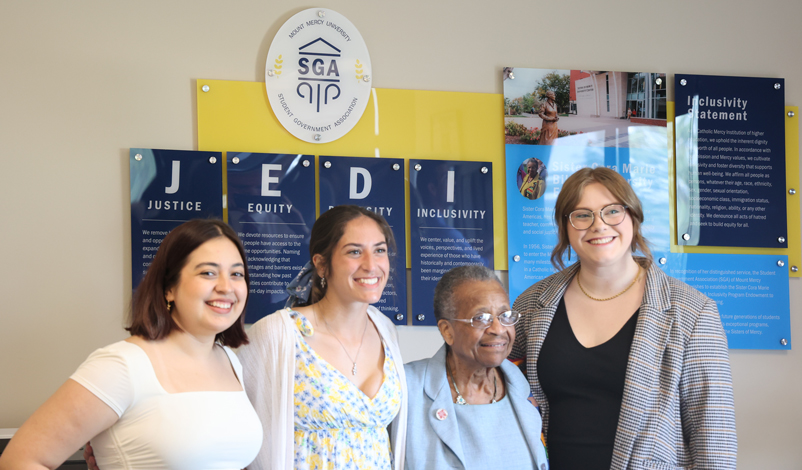 Students and university officials posing in front of the JEDI room sign