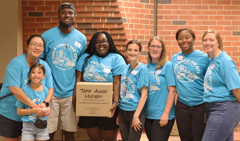 Eight volunteers smiling at the camera.