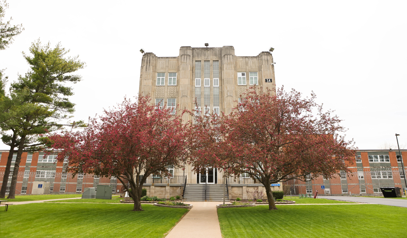 The Mount Pleasant Correctional Facility building, framed by blooming trees in the spring