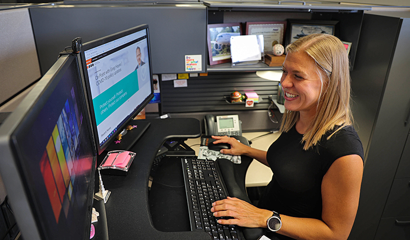 Piper smiling and working on her computer at Collins Aerospace