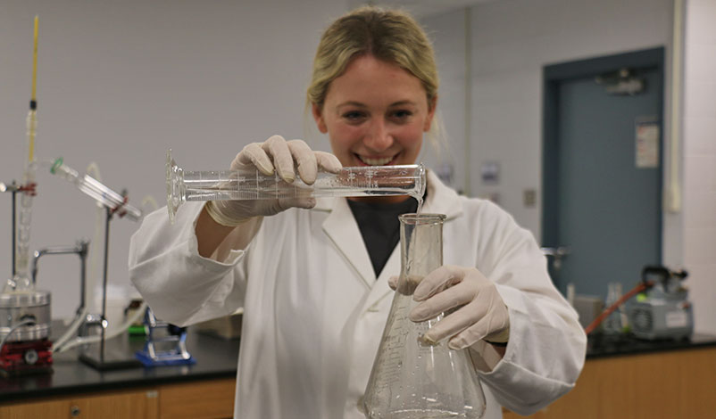 Peyton pouring liquid into a conical flask