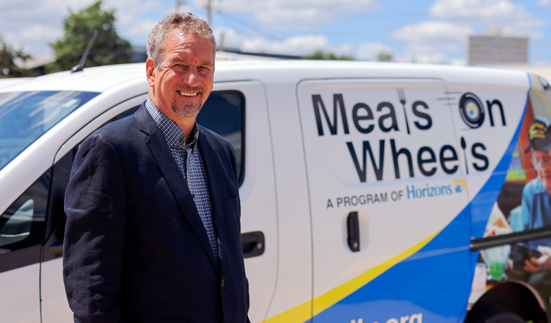 mike barnhart posing in front of meals on wheel truck