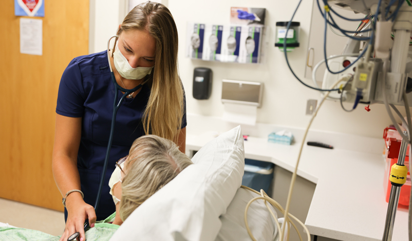 Becca checking in a patient's health