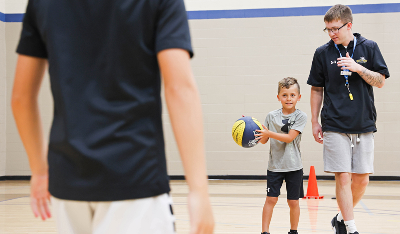 Jacob Perks, teaching a young boy to play basketball