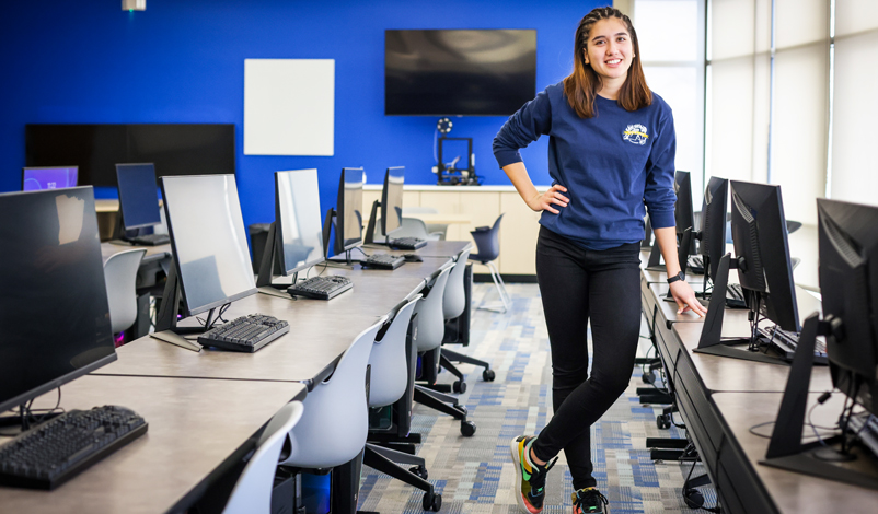 Nathalie Primbs '25 standing in the middle of Basile Hall's Data Science computer lab