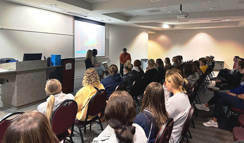 Mike White '89 speaking at a Mustang Leadership meeting in Flaherty Conference Room inBasile Hall