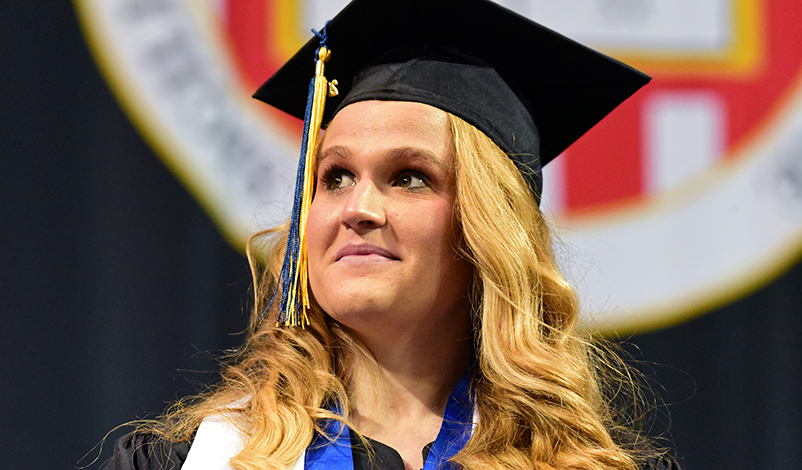 Amber Grimm standing on stage at Commencement