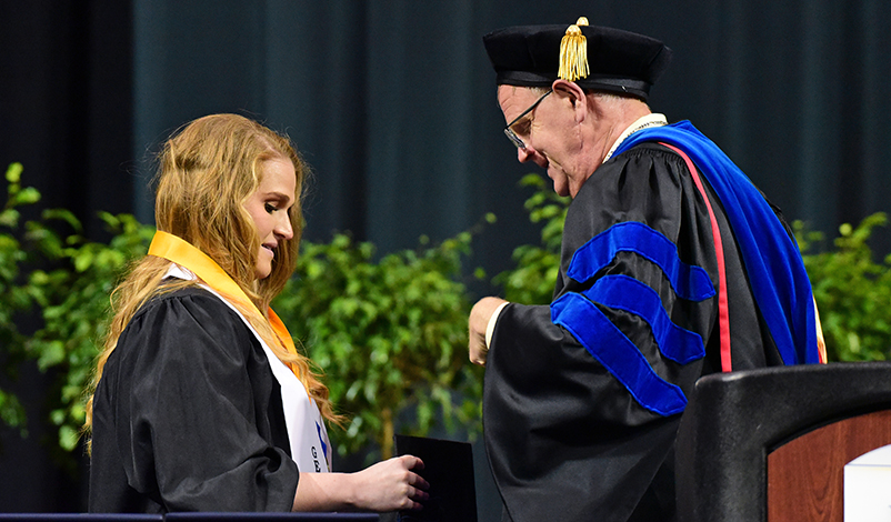 President Olson putting the award medallion around Amber's neck