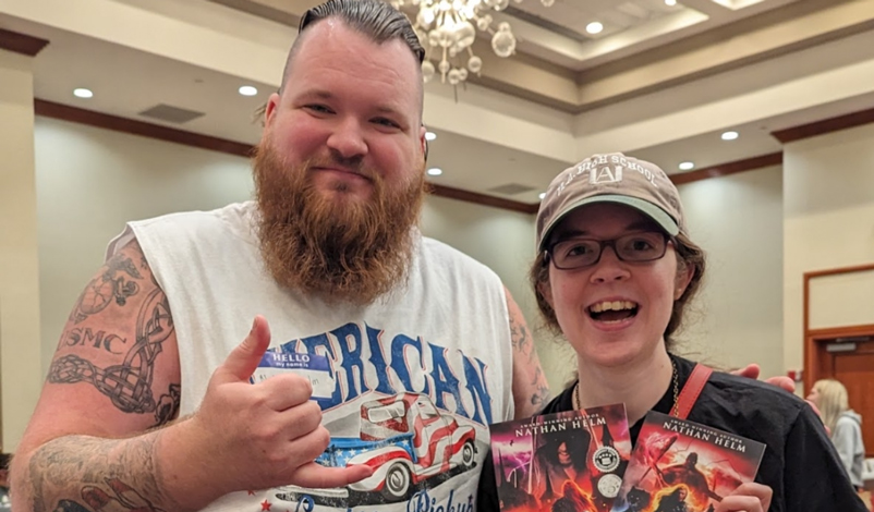 Nathan Helm smiling and posed with fan