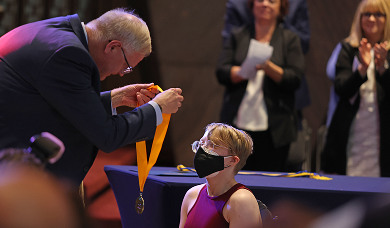 President Olson, placing the award medallion around Gwen's neck