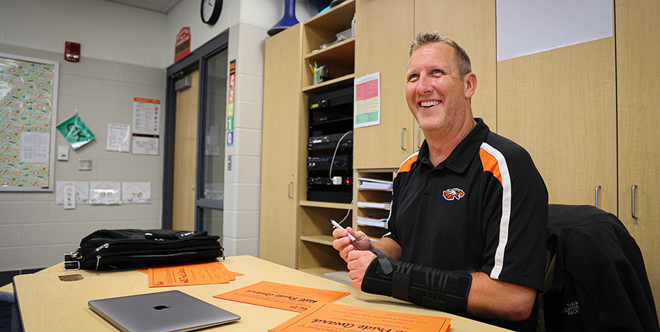 Brad Koch smiling at school desk