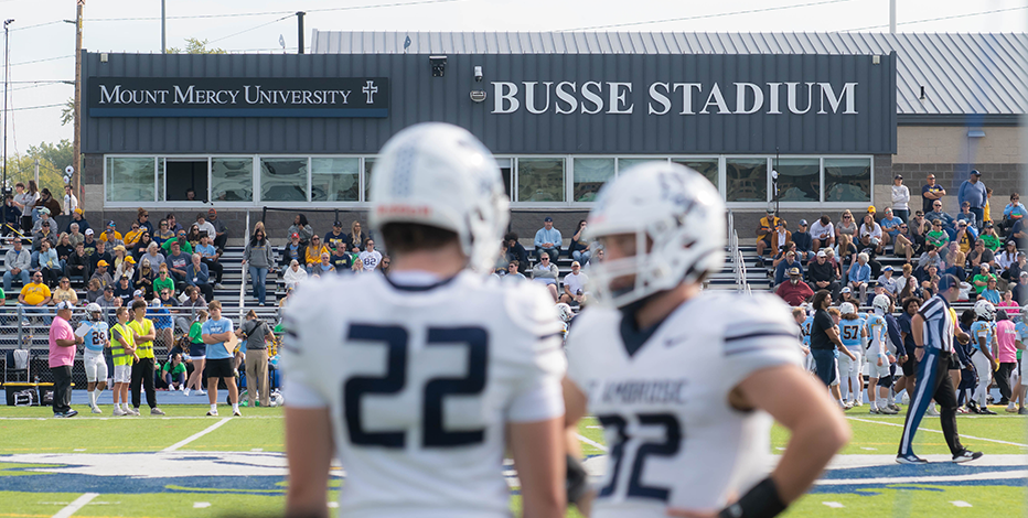 Two SAU football players stand on Mount Mercy University's Busse Stadium field during the Mercy Ambrose Classic.