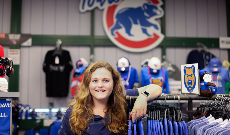 Katelyn Kral, posing in front of the Iowa Cubs logo